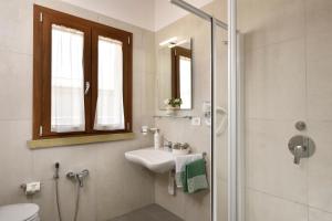 a white bathroom with a sink and a shower at Ville Borgo Verde in Vada