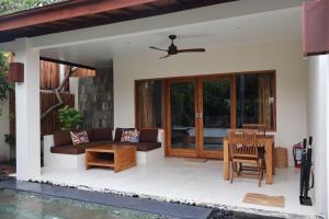 a patio of a house with a table and chairs at Dolce Magia in Gili Trawangan