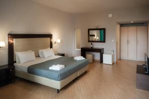 a hotel room with a bed and a television at Thalassa Hotel in Paleros