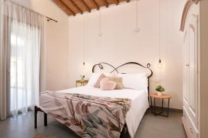 a bedroom with a bed with white sheets and pink pillows at Ville Borgo Verde in Vada