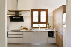 a kitchen with a sink and a window at Ville Borgo Verde in Vada +14 photos