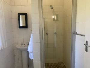 a bathroom with a shower and a sink at BillsBest Greengates Cottages in Port Edward