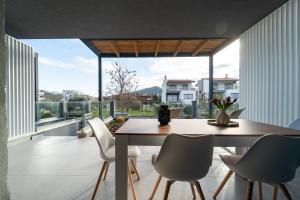 a dining room with a table and chairs and a large window at Aegean Grace Villa in Iraklitsa