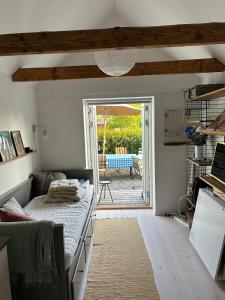 a bedroom with a bed and a patio with a table at Cosy guesthouse close to cities in Hjärup