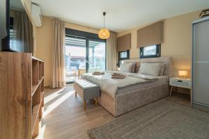 a bedroom with a large bed and a large window at Aegean Grace Villa in Iraklitsa
