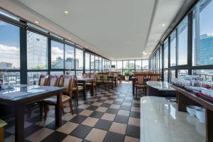 a restaurant with tables and chairs and windows at A25 Hotel - 15 Hàng Than in Hanoi