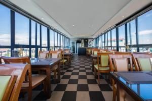 a restaurant with tables and chairs and windows at A25 Hotel - 15 Hàng Than in Hanoi +11 photos
