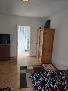 a room with a bed and a wooden cabinet and a door at Lieber Gruß 38 in Papenburg