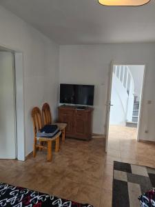 a living room with a tv and a table and chairs at Lieber Gruß 38 in Papenburg +5 photos