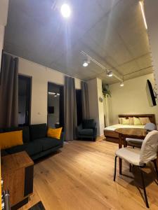 a living room with a bed and a couch and a table at Apartament Centrum 19 in Nowy Sącz