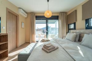 a bedroom with a large bed with towels on it at Aegean Grace Villa in Iraklitsa