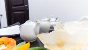 a group of white vases sitting on a table at Pearl Guest House in Dambulla