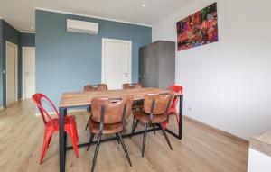 a dining room with a table and red chairs at Villa Piscine Privative in Saint-Florent