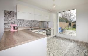 a kitchen with white cabinets and a pink appliance on a counter at Villa Piscine Privative in Saint-Florent