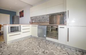 a large kitchen with white cabinets and appliances at Villa Piscine Privative in Saint-Florent