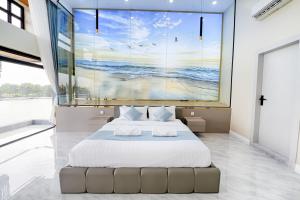 a bedroom with a bed and a large painting on the wall at The Cloud Homestay Kampot in Kampot