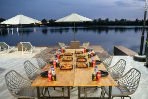 a wooden table with food and drinks on top of a lake at The Cloud Homestay Kampot in Kampot