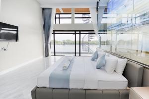 a large bed in a room with a large window at The Cloud Homestay Kampot in Kampot
