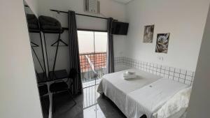 a bedroom with a bed and a large window at Hotel XV in Piracicaba