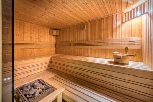 an empty wooden sauna with a bucket in it at Villa Jarosta Premium & SPA in Zakopane