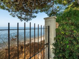 a gate to a beach with the ocean behind it at Estay - Villa Foxi Serenity - Exclusive holiday in Quartu SantʼElena
