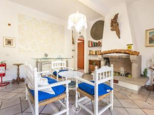 a living room with a table and chairs and a fireplace at Estay - Villa Foxi Serenity - Exclusive holiday in Quartu SantʼElena
