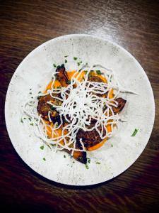 ein Teller Spaghetti mit Käse auf einem Tisch in der Unterkunft Wolfstein - Le Boutique Hotel in Bad Harzburg