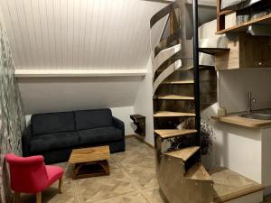 a living room with a black couch and a red chair at Gîte les Crayons in Gaillon +2 photos