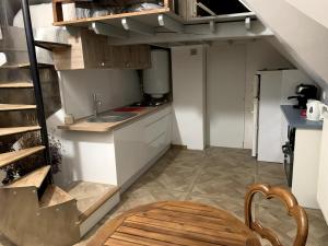 a small kitchen with a sink and a staircase at Gîte les Crayons in Gaillon
