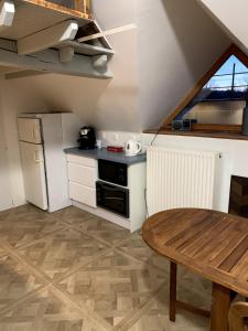 a small kitchen with a table and a refrigerator at Gîte les Crayons in Gaillon
