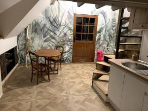 a kitchen with a table and chairs and a sink at Gîte les Crayons in Gaillon