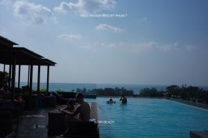 a group of people sitting in a swimming pool at Suite With Sea View By Mida Grande Resort in Surin Beach