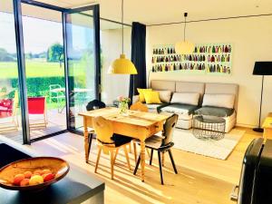 un soggiorno con un tavolo e un divano di simsseeLOFT - Ferienapartments in Baierbach am Simssee a Stephanskirchen