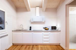 a kitchen with white cabinets and a microwave at Palline Chalet by Hili in Rome +3 photos