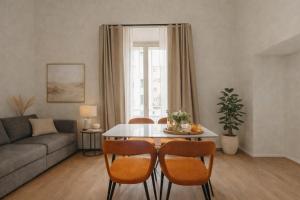a living room with a couch and a table and chairs at Cavour Suites in Ancona