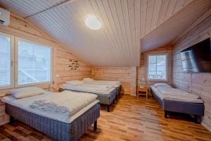 a room with three beds and a flat screen tv at Villa Lily ski slopes 300 m, Jacuzzi for extra fee in Himos