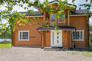 a small house with a white door and a porch at Villa Lily ski slopes 300 m, Jacuzzi for extra fee in Himos