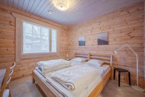 a bedroom with a bed in a wooden room at Villa Lily ski slopes 300 m, Jacuzzi for extra fee in Himos