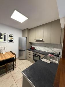 a kitchen with stainless steel appliances and a table at Carisa rooms for holiday in Larnaca