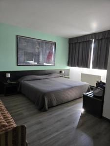 a bedroom with a bed and a painting on the wall at Green Hotel in Poviglio