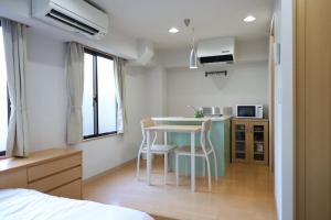 a small kitchen with a table and chairs in a room at Hotel LEAP in Osaka