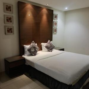 a bedroom with a large white bed with two pillows at شقق ذرا الماضي المخدومه2 in Al Bukayriyah