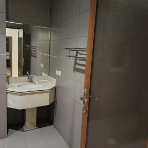 a bathroom with a sink and a mirror at شقق ذرا الماضي المخدومه2 in Al Bukayriyah