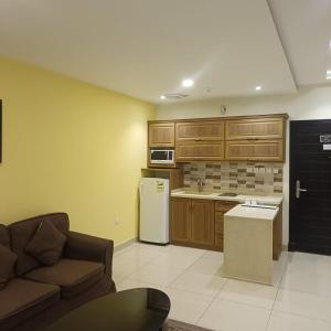 a kitchen with a couch and a refrigerator at شقق ذرا الماضي المخدومه2 in Al Bukayriyah