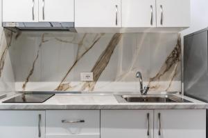 a kitchen with a sink and white cabinets at Green Luxe Suite 1 by PikHost in Shkodër +52 photos