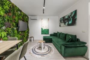 a living room with a green couch and a table at Green Luxe Suite 1 by PikHost in Shkodër