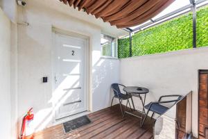 a balcony with a door and two chairs and a table at Green Luxe Suite 1 by PikHost in Shkodër
