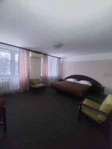 a bedroom with a bed and a chair and a window at Motel Poltava in Poltava +41 photos