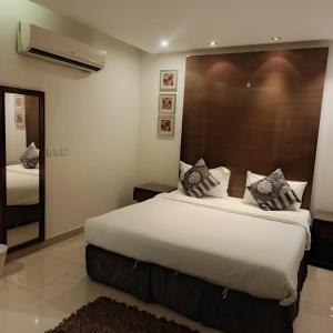 a bedroom with a large bed and a mirror at شقق ذرا الماضي المخدومه2 in Al Bukayriyah +6 photos