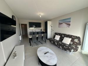 a living room with a couch and a table at T3 Rénové vue mer in Saint-Jean-de-Monts